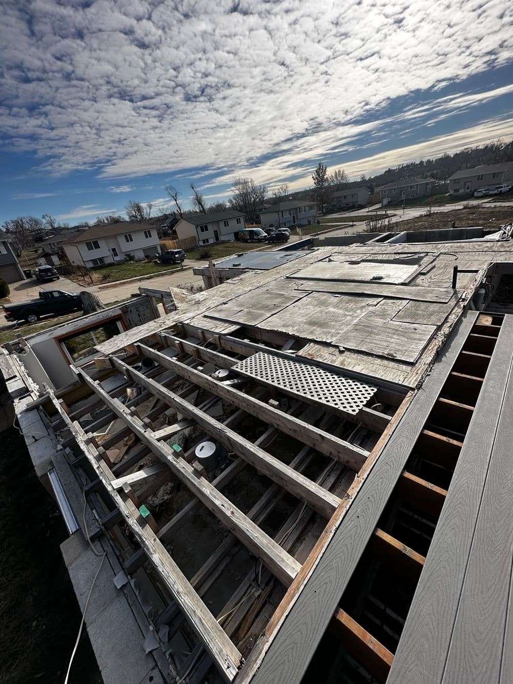 Construction site showing wooden beams and foundation preparation under a cloudy sky.