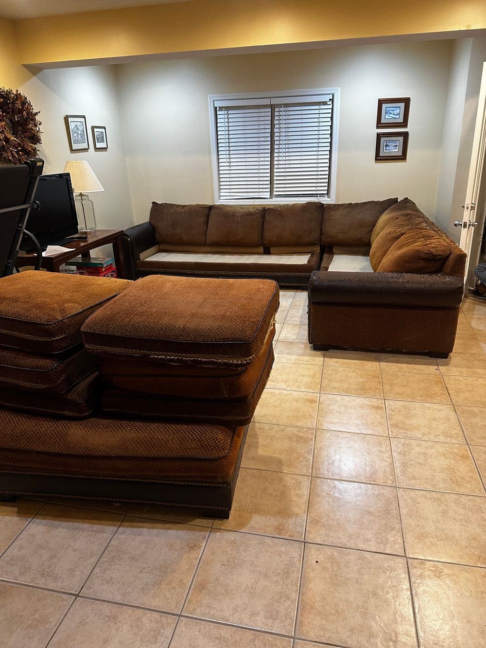 Brown sectional sofa with stacked cushions in a well-lit living room. Sliding doors in background.