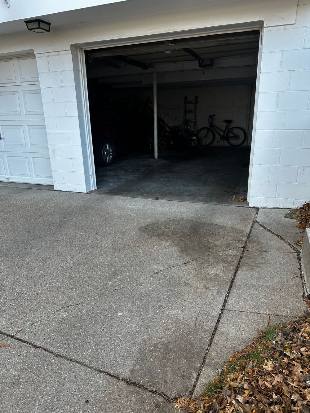 Empty garage with concrete floor and bicycles in the background.
